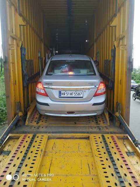 Professional car transport: a silver sedan safely loaded inside an enclosed shipping container for maximum protection.