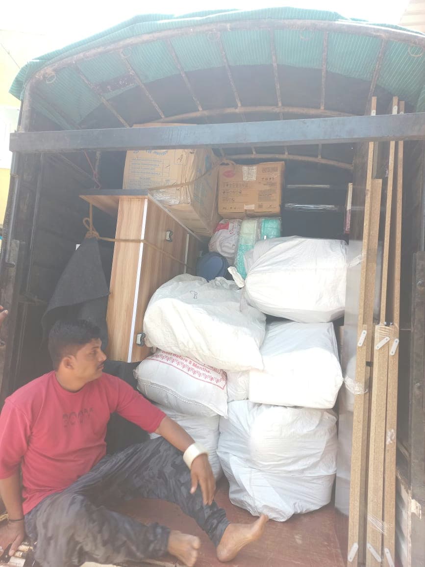 Inside a moving truck packed with furniture, sacks, and household items ready for safe transport.