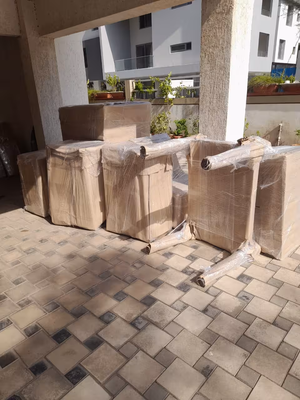 Securely wrapped office furniture organized outdoors for efficient loading.