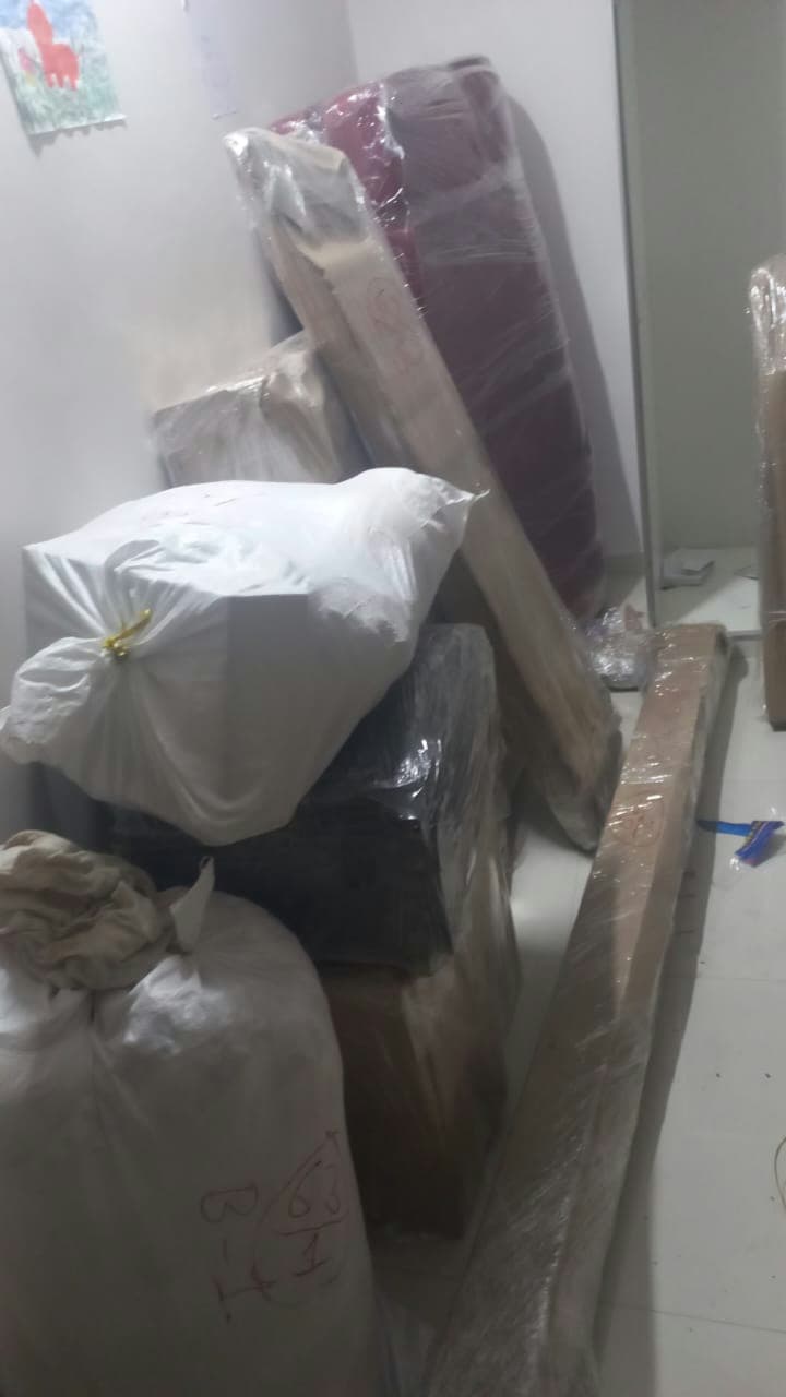 Expert packing of various household items, including mattresses, bed frames, and linens in protective sacks.