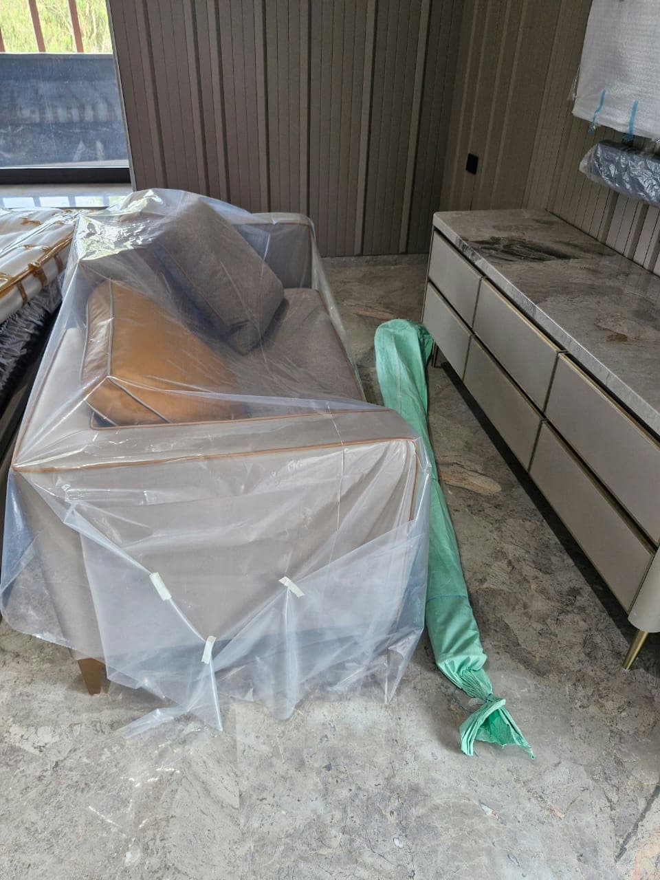 Using protective plastic covers to shield delicate sofa upholstery from dust and moisture during the move.