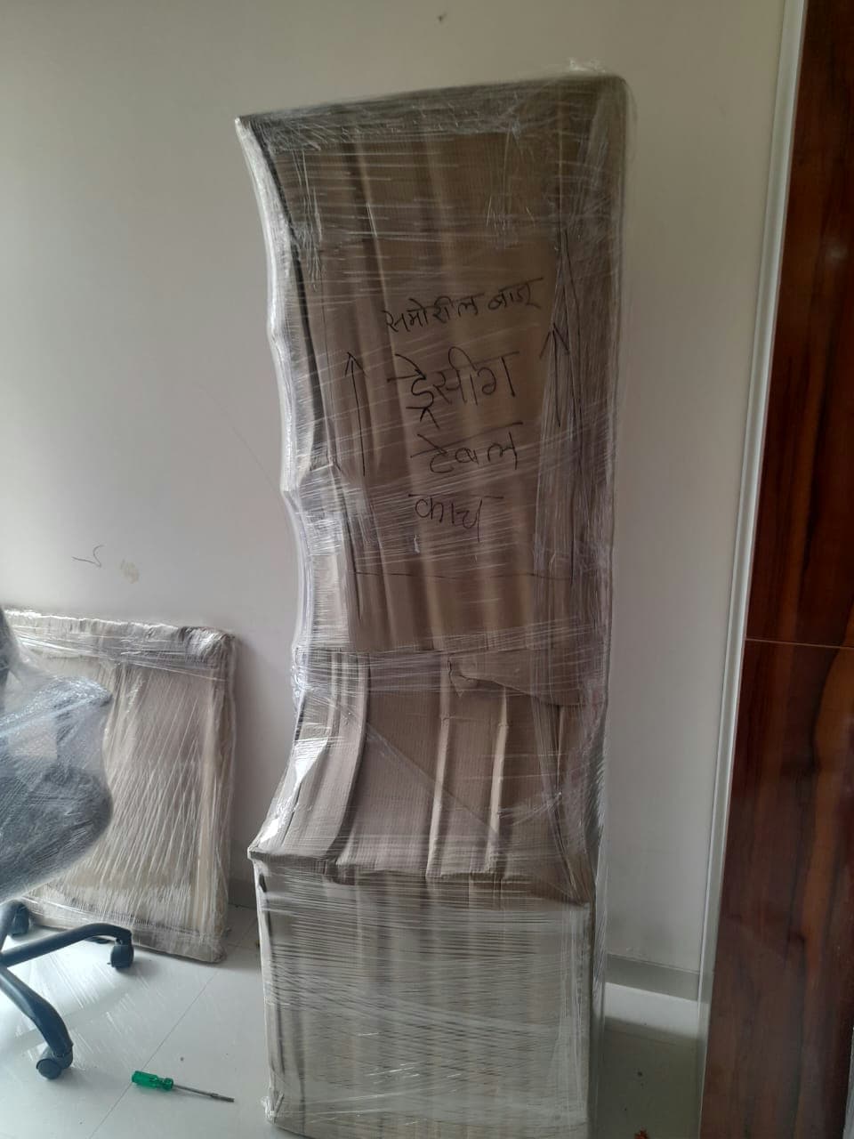 Custom wrapping for a dressing table with clear, handwritten labels for careful handling of glass parts.
