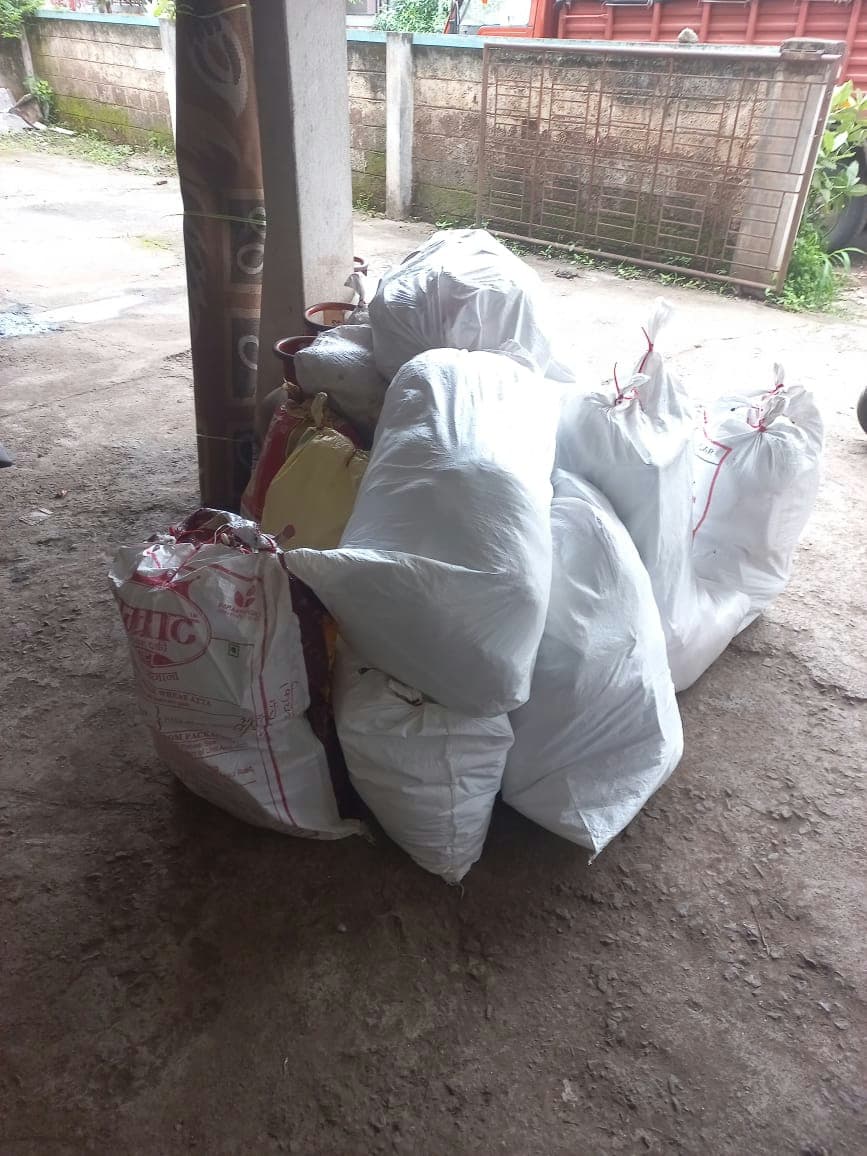 Securely tied sacks containing soft goods and clothing, ready to be loaded onto the moving truck.