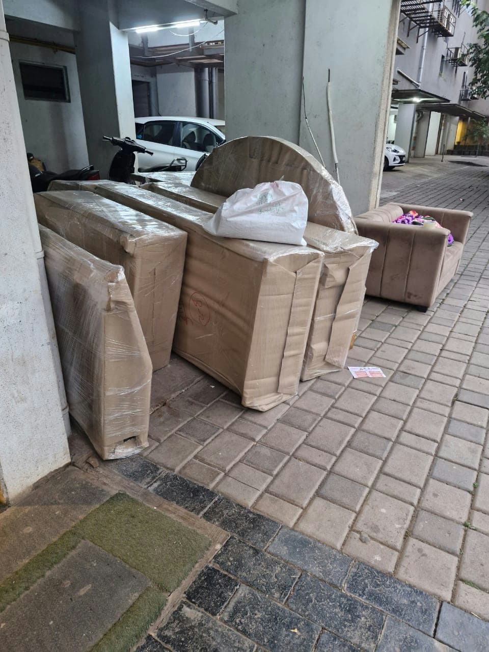 Professionally wrapped furniture pieces staged in a building's common area for efficient moving.